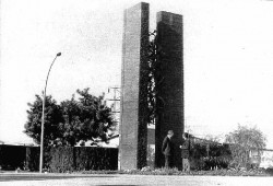 Monumento emplazado en el patio de la fábrica <em><span style="color: #ff0000;"><strong>Montesa</em></span></strong>, en Esplugues de Llobregat, encargado por Pere Permanyer al escultor José Mª. Subirachs (ambos en la foto) con motivo del 25 aniversario de la compañia.<br>Consta de un "amasijo" de piezas históricas soldadas entre sí, que se sostienen entre dos columnas rectangulares donde están inscritos los nombres de todos los modelos realizados y firmado por todos los trabajadores. 